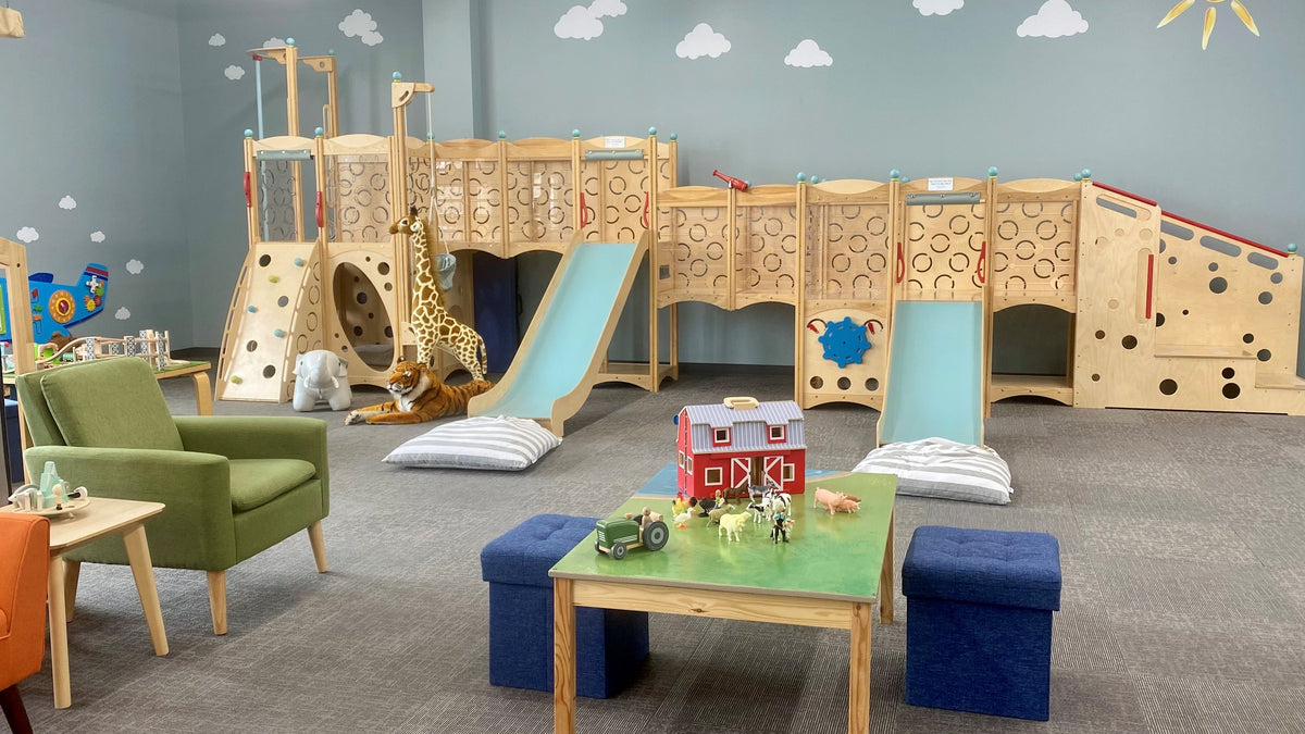 Children's playroom with wooden play structure, furniture, and toys.