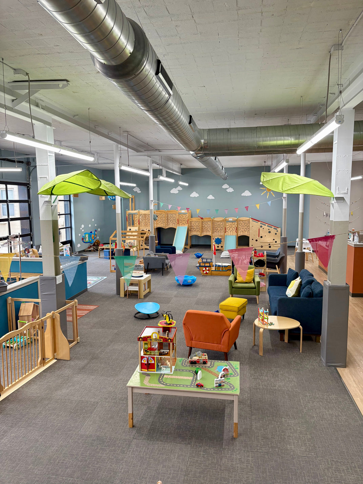 Inside Bug & Goose’s Elm Grove location, Wisconsin play café, with wooden climbing structures, slides, toys, and seating.